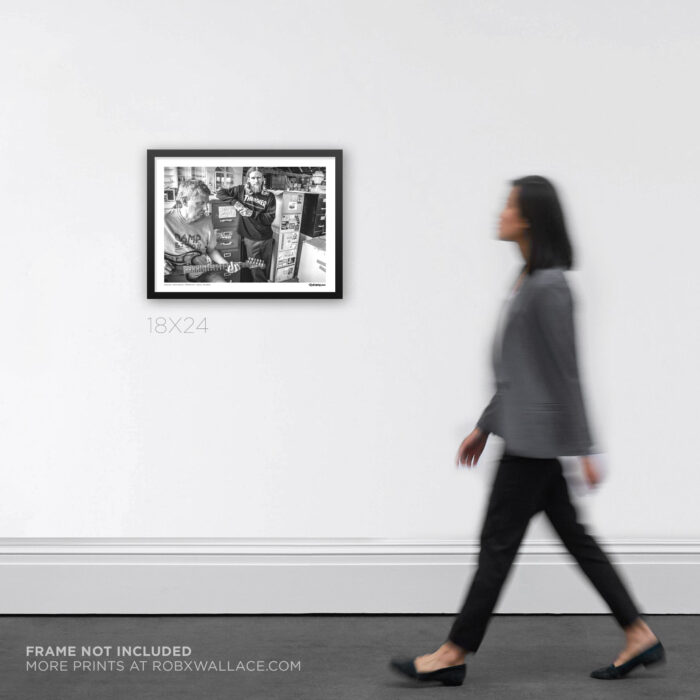 18x24 wide framed hardcore punk history print documenting Greg Ginn and Mike Vallely at the Taylor Texas archive warehouse, shown on a wall for product scale.