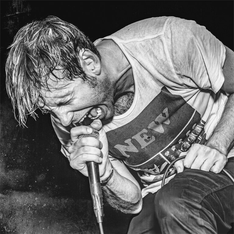 Geoff Rickly screaming into the microphone live with hardcore punk supergroup United Nations at The Constellation Room in Santa Ana, California.