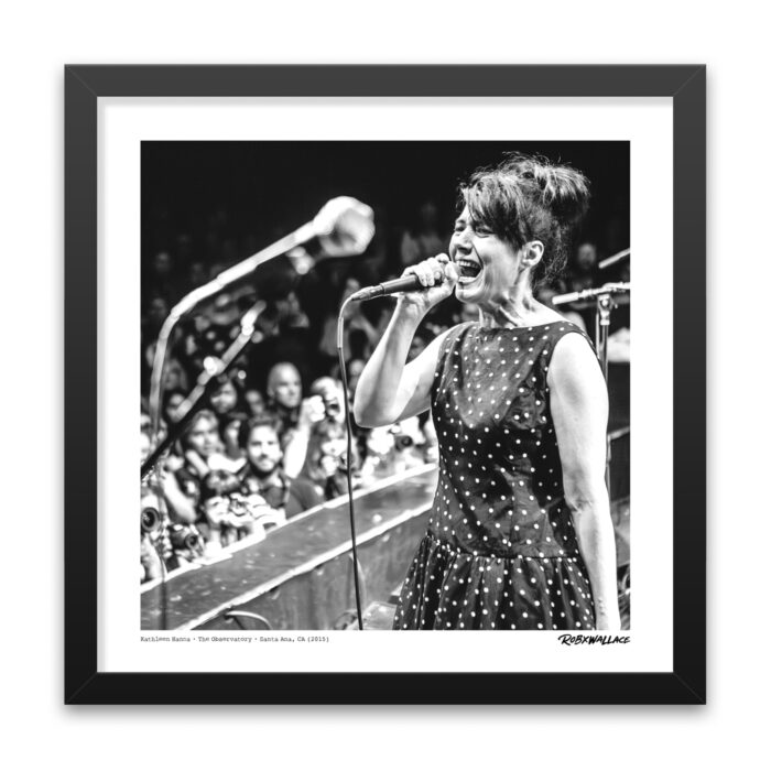 Close up view of an 18x18 square framed feminist punk poster print singer Kathleen Hanna in her polka dot dress and beehive hairstyle.