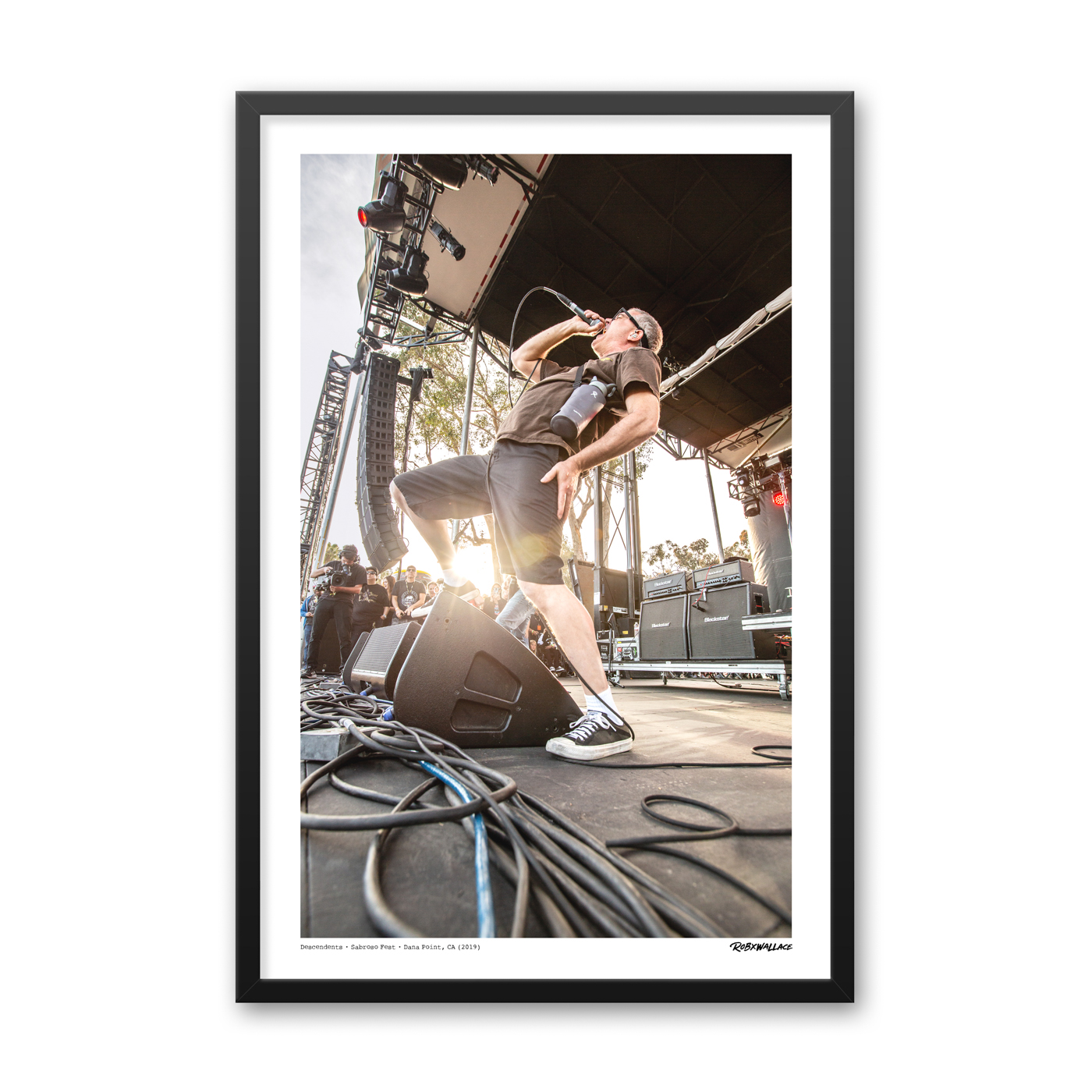 Close up view of a 24x36 tall framed punk rock poster print frontman Milo Aukerman in his signature live stance with his water jug strapped to his side.