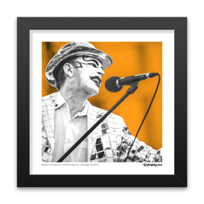 Detailed close up of a 12x12 square framed orange color-block punk poster print highlighting the theatrical performance art stage presence of The Adicts.
