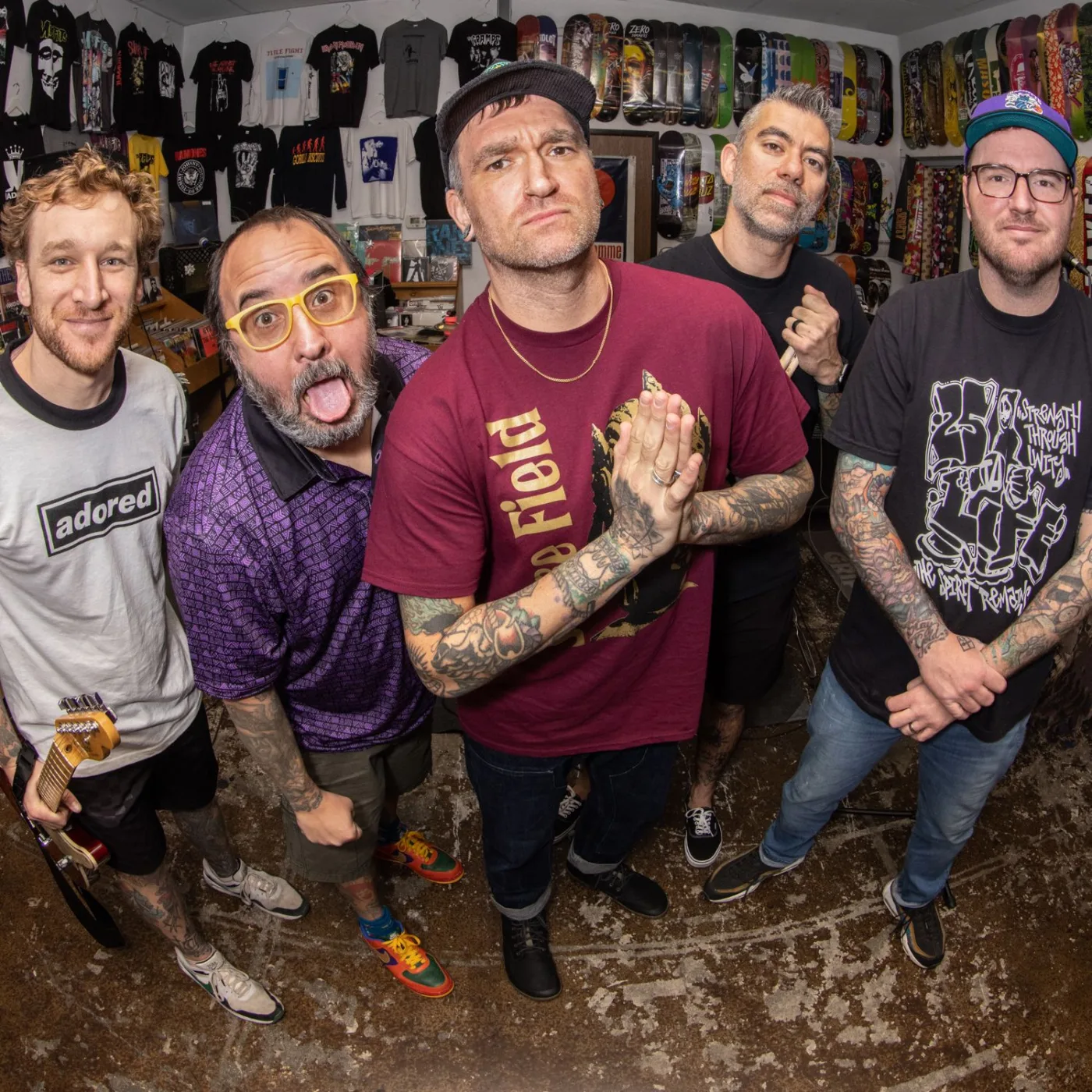 Group band portrait photograph by RobxWallace capturing Jordan Pundik, Chad Gilbert, Ian Grushka, and Cyrus Bolooki of pop punk legends New Found Glory hanging out together inside the brick interior of Programme Skate Sound in Fullerton, California.