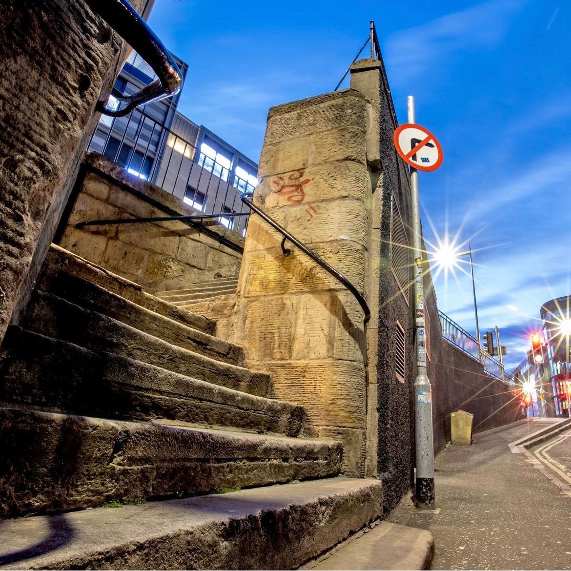 Cinematic film location street photography print by Rob Wallace showcasing the historic Calton Road stairs in Edinburgh, Scotland, famous for the opening chase scene where Ewan McGregor as Mark Renton runs from the police in the movie Trainspotting.